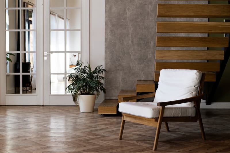 Ingresso in stile quiet luxury con parquet e scala in legno