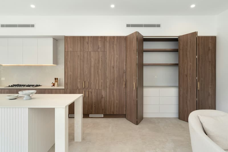 cucina su misura di design con mobile dispensa in legno e isola